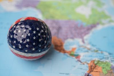American flag golf ball over world map